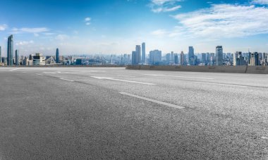 Panoramik ufuk çizgisi ve modern binalarla dolu boş asfalt yol