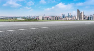 Panoramik ufuk çizgisi ve modern binalarla dolu boş asfalt yol