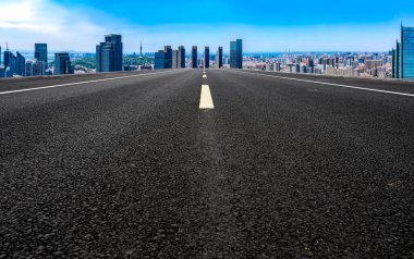 Panoramik ufuk çizgisi ve modern binalarla dolu boş asfalt yol