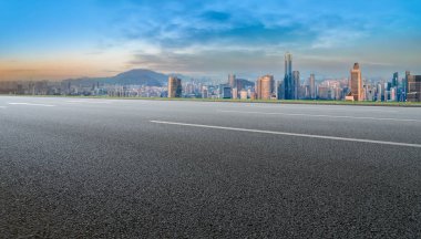 Panoramik ufuk çizgisi ve modern binalarla dolu boş asfalt yol