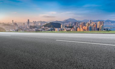 Panoramik ufuk çizgisi ve modern binalarla dolu boş asfalt yol