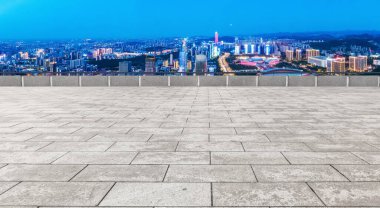 Boş tuğla zemin ve şehrin ufuk çizgisi arka planı