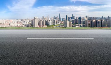 Panoramik ufuk çizgisi ve modern binalarla dolu boş asfalt yol