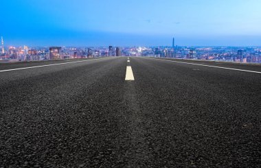 Panoramik ufuk çizgisi ve modern binalarla dolu boş asfalt yol