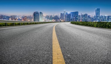 Panoramik ufuk çizgisi ve modern binalarla dolu boş asfalt yol