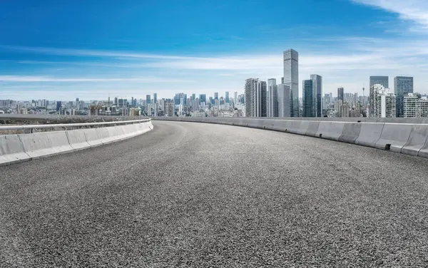 Panoramik ufuk çizgisi ve modern binalarla dolu boş asfalt yol