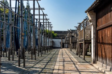 Wuzhen, Çin 'de boyama atölyesinde kumaş şeritleri asmak
