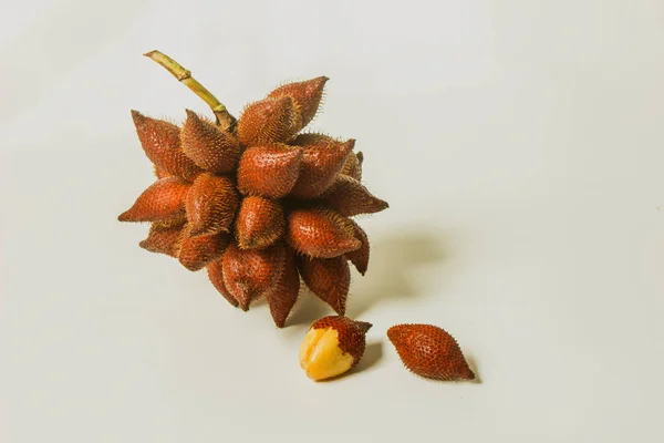 Snake fruit is a delicious sweet and sour fruit on a white background.