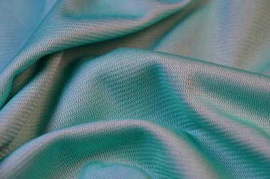 İnce zikzak desenli mavi-yeşil deniz mavisi kumaşına yakın çekim, desen ve kıvrımlar.