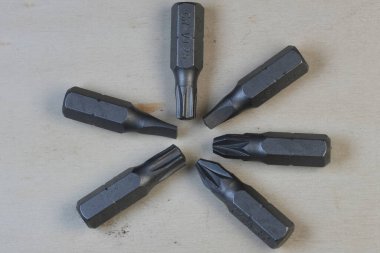 Işık yüzeyinde daire şeklinde dizilmiş altı farklı tornavida parçası..