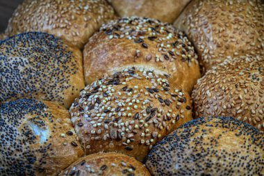 İçinde haşhaş ve susam tohumlarının da bulunduğu çeşitli ekmeklerin yakın çekimi..