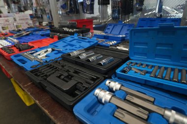 Gent Flanders Belçika 02: 16 2025 Mavi, kırmızı ve siyah çantalarda çeşitli açık araç setleri bir mağazadaki ahşap masada satılmaya hazır bekliyor..