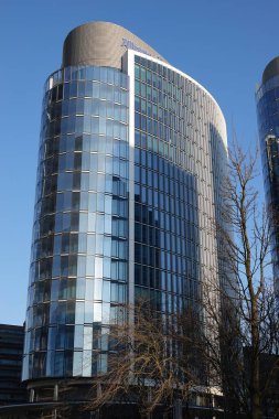 Brüksel Kuzeyi, Brabant, Belçika 03: 20 2025 Pürüzsüz, aynalı Allianz Sigorta ofis kulesi berrak bir gökyüzüne yükselir, cam dış görünüşüyle ışığı yansıtır, görsel olarak çarpıcı bir dönüm noktası yaratır..