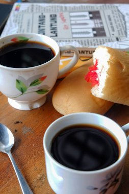 Evinin ön bahçesinde çay içen birinin yakın plan fotoğrafı.