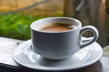 Bir fincan sütlü kahve fotoğrafı. Beyaz seramik bardak. Düz yatıyordu