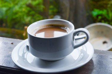 Bir fincan sütlü kahve fotoğrafı. Beyaz seramik bardak. Düz yatıyordu