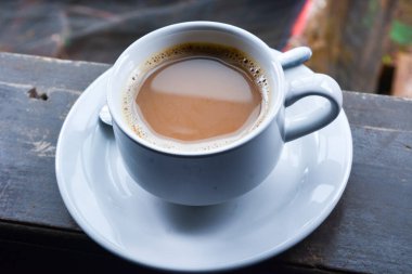 Bir fincan sütlü kahve fotoğrafı. Beyaz seramik bardak. Düz yatıyordu