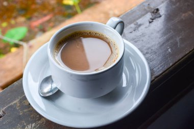 Bir fincan sütlü kahve fotoğrafı. Beyaz seramik bardak. Düz yatıyordu