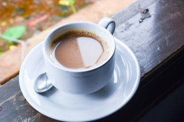 Bir fincan sütlü kahve fotoğrafı. Beyaz seramik bardak. Düz yatıyordu