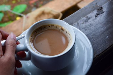 Bir fincan sütlü kahve fotoğrafı. Beyaz seramik bardak. Düz yatıyordu