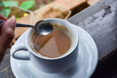 Bir fincan sütlü kahve fotoğrafı. Beyaz seramik bardak. Düz yatıyordu