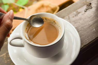 Bir fincan sütlü kahve fotoğrafı. Beyaz seramik bardak. Düz yatıyordu