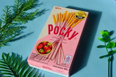 Wonosobo, Endonezya 23 Nisan 2023: Pembe ambalajda çilekli çerezler. Mavi arkaplana karşı