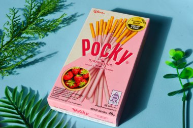 Wonosobo, Endonezya 23 Nisan 2023: Pembe ambalajda çilekli çerezler. Mavi arkaplana karşı