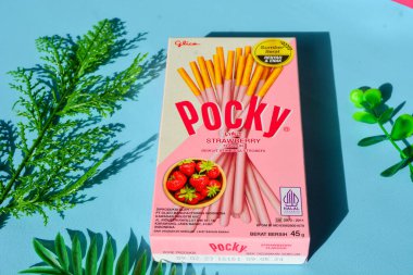 Wonosobo, Endonezya 23 Nisan 2023: Pembe ambalajda çilekli çerezler. Mavi arkaplana karşı