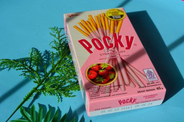 Wonosobo, Endonezya 23 Nisan 2023: Pembe ambalajda çilekli çerezler. Mavi arkaplana karşı