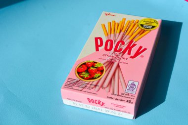 Wonosobo, Endonezya 23 Nisan 2023: Pembe ambalajda çilekli çerezler. Mavi arkaplana karşı