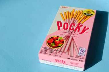 Wonosobo, Endonezya 23 Nisan 2023: Pembe ambalajda çilekli çerezler. Mavi arkaplana karşı