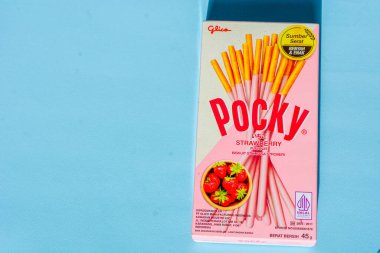 Wonosobo, Endonezya 23 Nisan 2023: Pembe ambalajda çilekli çerezler. Mavi arkaplana karşı