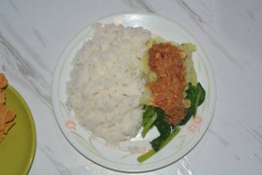 Beyaz arka planda bir tabak pekel pilavı..