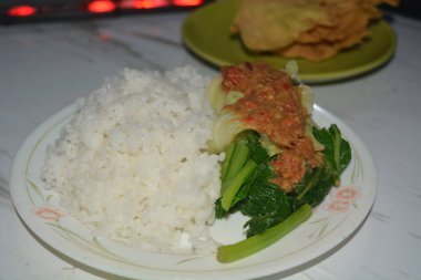 Beyaz arka planda bir tabak pekel pilavı..