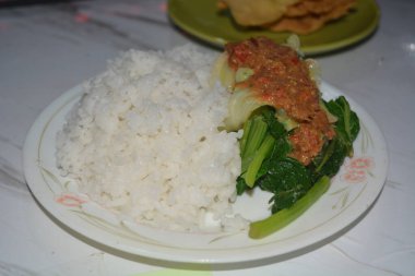 Beyaz arka planda bir tabak pekel pilavı..