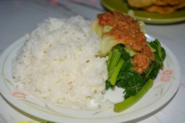 Beyaz arka planda bir tabak pekel pilavı..