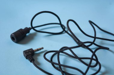 Beyaz arkaplanda siyah mikrofon kablosu.