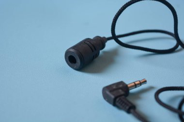 Beyaz arkaplanda siyah mikrofon kablosu.