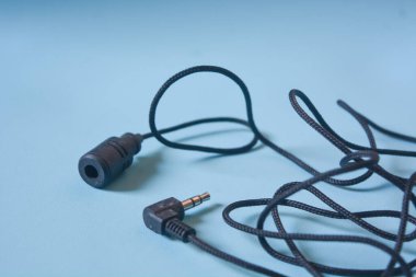 Beyaz arkaplanda siyah mikrofon kablosu.