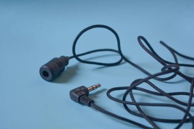 Beyaz arkaplanda siyah mikrofon kablosu.