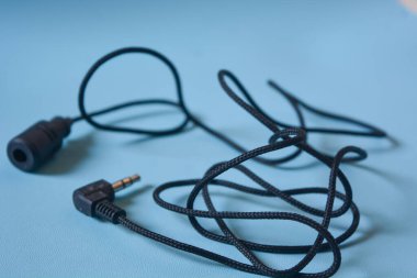Beyaz arkaplanda siyah mikrofon kablosu.