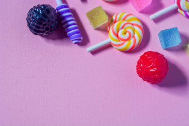 Küçük çocukların en sevdiği şekerleme dümdüz uzanıyordu. Renkli lolipoplar, şekerler, çikolatalar. Pembe arkaplan