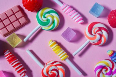 Küçük çocukların en sevdiği şekerleme dümdüz uzanıyordu. Renkli lolipoplar, şekerler, çikolatalar. Pembe arkaplan