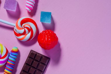 Küçük çocukların en sevdiği şekerleme dümdüz uzanıyordu. Renkli lolipoplar, şekerler, çikolatalar. Pembe arkaplan