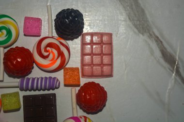 Pembe arka planda lezzetli görünen çeşitli renkte tatlı çörekler.