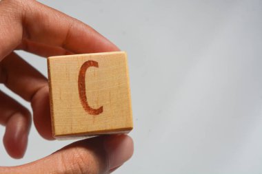 Tahta blokta C harfi alfabesi. Beyaz bir arka planda izole edilmiş. Eğitim.