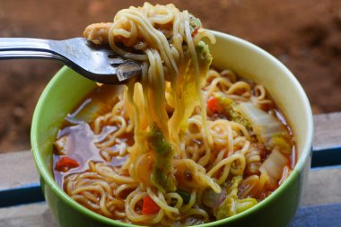 Boiled instant noodles topped with various vegetables.