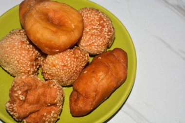 Donuts and dumplings on a small plate on a white background.