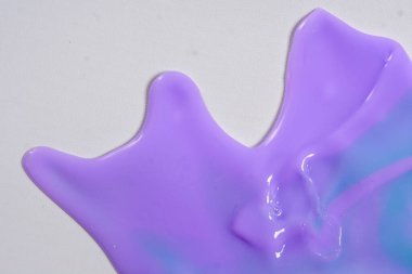 Colorful leaking paint liquid spills from close range